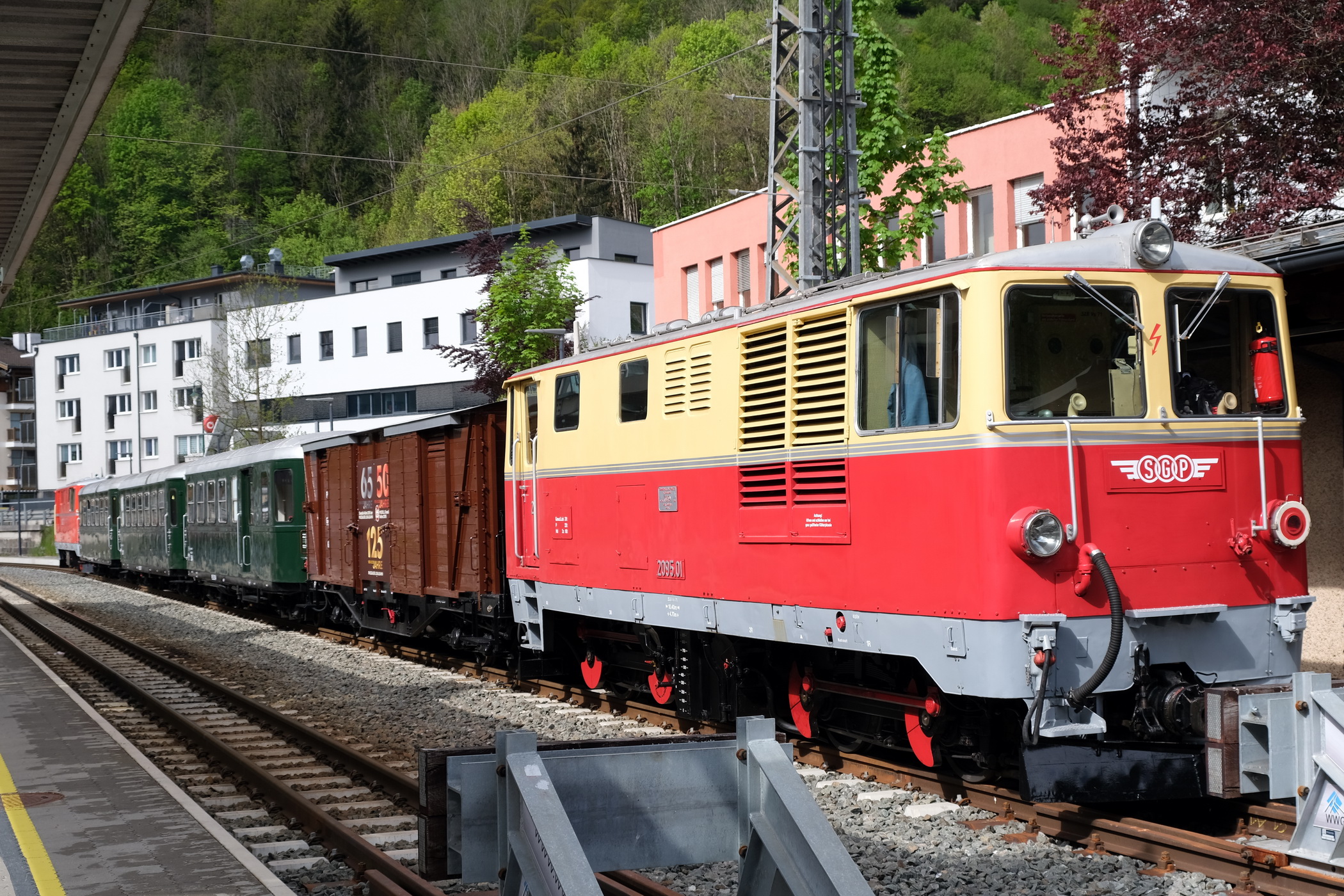 Ganzzug mit SGB 2095.01 in rot/beige Nr. 2095.01 mit dem Jubiläumsgüterwagen PLB - GGm_s 601 (LGB Museumswagen 2023), mit 3 Personenwagen Bauart B4ip_s, Nr. 354, Nr. 307 und Nr.306 und der Lok ÖBB 2095.04 der ÖBB in rot .