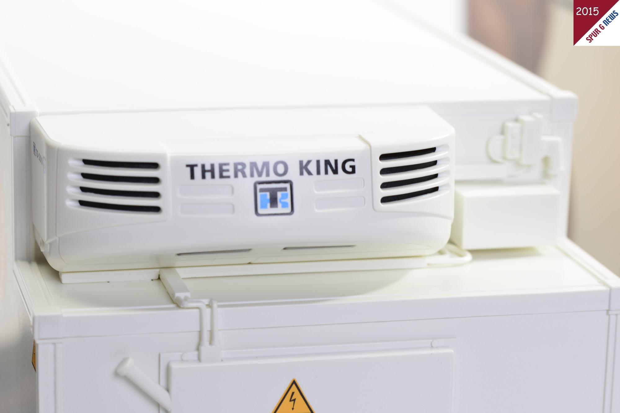 Grere Aufnahme des Khlaggregates der Firma THERMO KING auf dem Khlcontainer. Ausgleichsbehlter und Aggregat sind an der Frontseite mit feinen Leitungen angeschlossen. Warnhinweis auf Khlmittel ist aufgedruckt. 