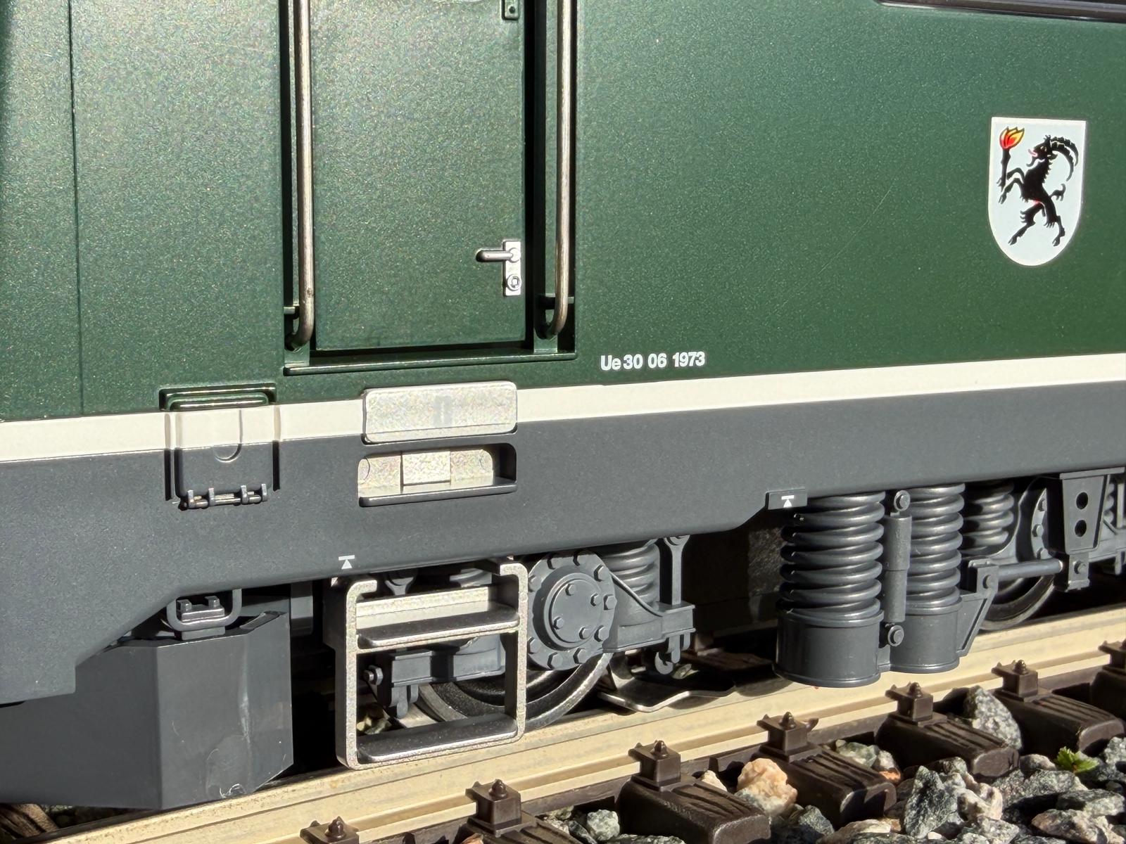 Der Einstieg in die Ge 4/4 II im grnen Kleid mit Aufstieg, Trgriffen und der zu ffnenden Tr. Auch das Wappen und die UE 30 06 1973.