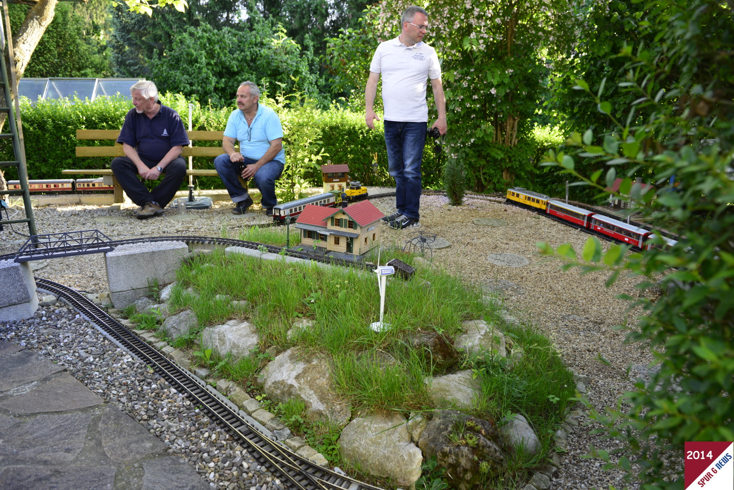 Eingang wurde bereits der "Tafelberg" hnlich dem Walberla in der Frnkischen Schweiz erwhnt. Hier nun links im Bild der angelegte Berg mit dem Ausflugsbahnhof und integrierter Gaststtte ohne Zug. Rechts im Bild der "Ausflugszug" der doch eine gute Bergstrecke ohne Zahnrad bewltigen kann. Auch moderne Energieerzeugung wird auf der Erabocher Gartenbahn eingesetzt. Kleines Windrad fr die Versorgung des Bahnhofes mit Gaststtte.