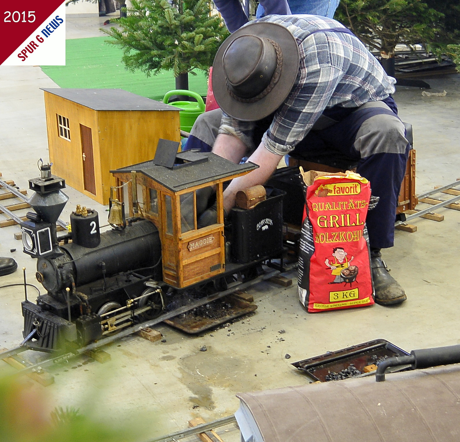 Der Eisenbahner auf der 5 Zoll Bahn vom Bren Tal  grillt keine Wrstchen auf dem Rost der Lokomotive. Nach dem Auskehren des Ascherostes, dem nachfllen mit Wasser fr die Dampferzeugung wurde die Feuerbchse der US Lok mit der guten favorit Grillholzkohle angefeuert um ordentlich Dampf zu haben. Ob hier Grillkohle oder doch Antrazitkohle im 3 KG Sack war haben wir nicht eroiert. Dafr haben die Dampfbahner vom Bren Tal mal wieder volle Arbeit im Holzfllercamp auf dem Echtdampftreffen in der Messe Karlsruhe geleistet. Das Publikum war begeistert.