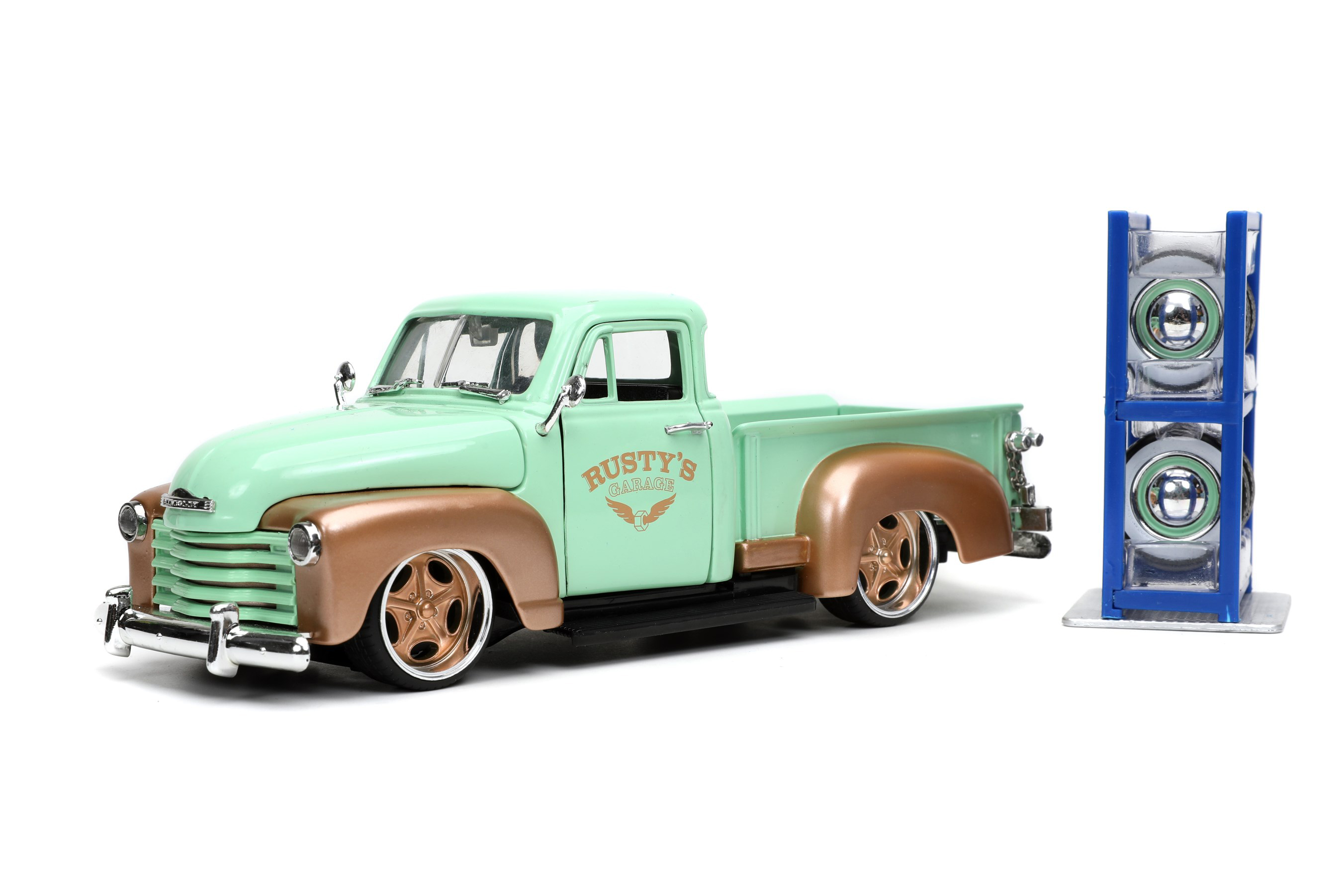 Modell eines Chevy Pick Up aus dem Jahr3 1953. Die von General Motors gebauten Pick Ups hatten an Vorne und hinten ausgestellte Kotflgel. Der mintgrne Chevy ist mit dem kupferfarbenen LOGO RUSTY`S Garage, kupferfarbenen Kotflgeln und zwei Stzen von Felgen mit Reifen hergestellt. Die "gepimpten" Niederquerschnittsreifen mit kupferfarbenen Felgen knnen gegen die klassischen Felgen mit Weiwandreifen und Chromradkappen ausgetauscht werden. Ein Reifenregal in blau liegt der Packung bei. Schraubendreher ist fr die Montage ebenfalls im Lieferumfang enthalten. 