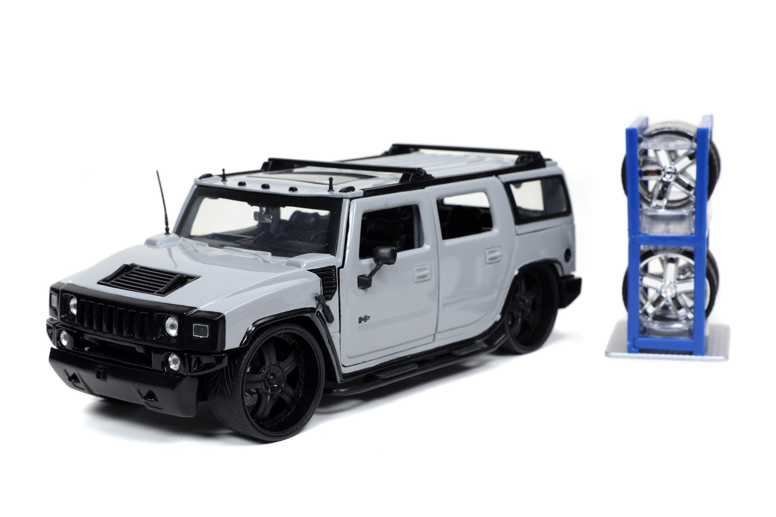 Modell eines zivilen Hummer H2 in grau mit schwarzer Front und Anbauteilen. Auch bei diesem Modell sind Ersatzfelgen in Chromoptik sowie das Felgenregal enthalten. auch der Schraubendreher gehrt zur Ausstattung. 