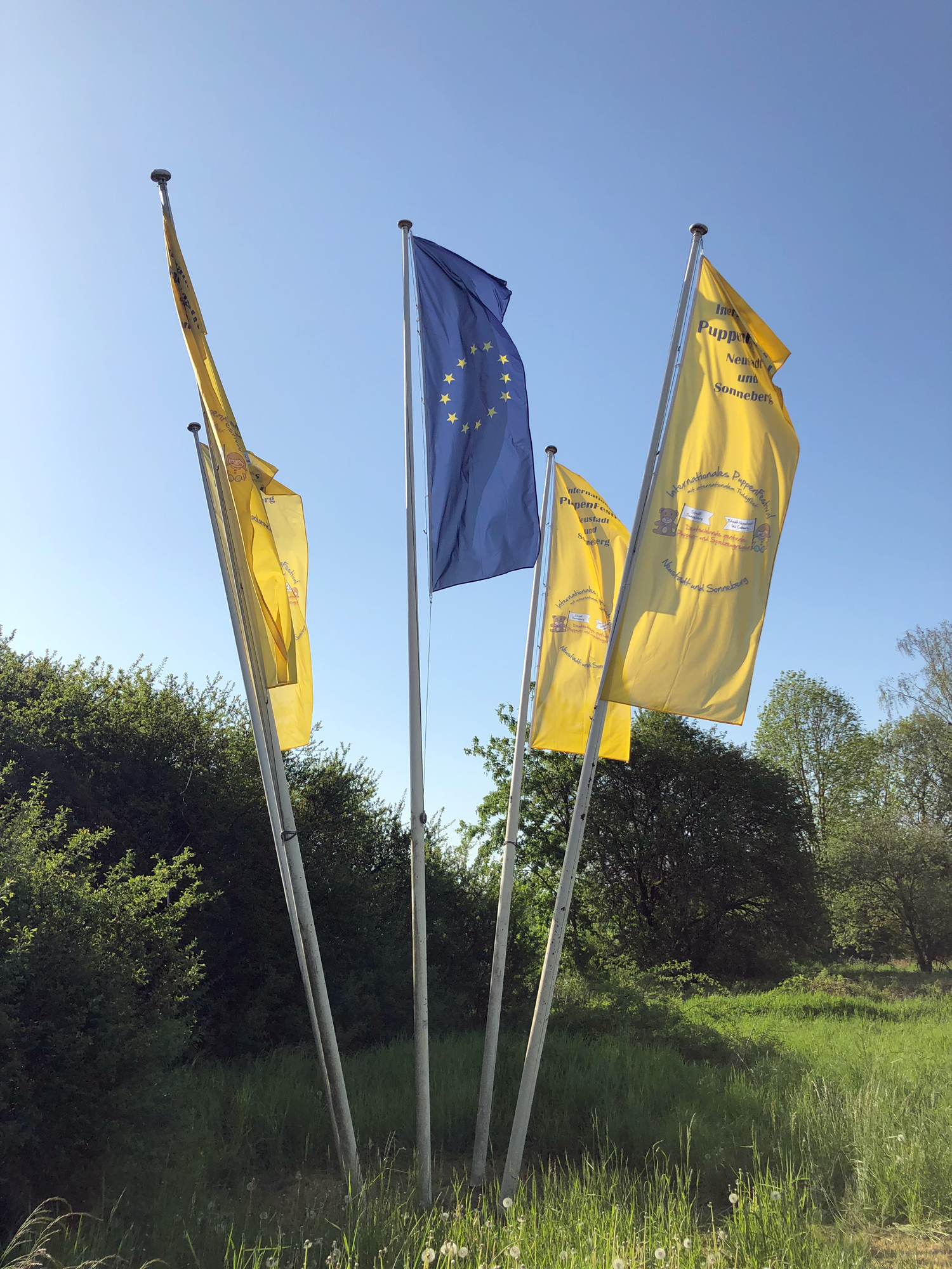 Schon am Eingang der Stadt begrt EUROPA und das Puppenfestival mit einer Fahnenanordnung die Gste. Das Wetter ist fast schon zu schn fr die Veranstaltung in der Halle. Aber die Puppen sind empfindlich. Es knnte ja auch Regnen. 