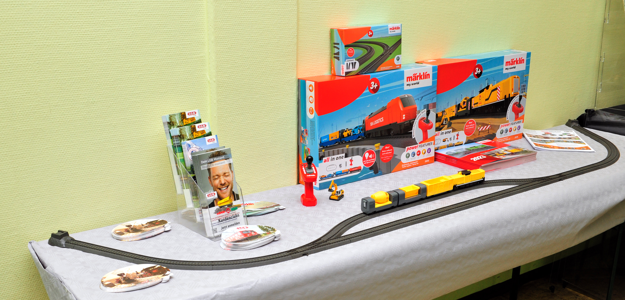 Das hatten wir gestern erwähnt: LGB / Märklin hat in der Mehrzweckhalle auch einen Stand mit Produkten der LGB Familie und Märklin mit Start Up aufgebaut. Hier nun für die junge Generation "START UP" Anfangspackungen mit Ergänzung. Aufgebaut ist der gelbe Zug, besehend aus Diesellok und drei Güterwagen. Der Bagger und die Fernbedienung sind mit dabei. Ein Gleisoval mit Ausweichstelle kann aus dem Startset aufgebaut werden.