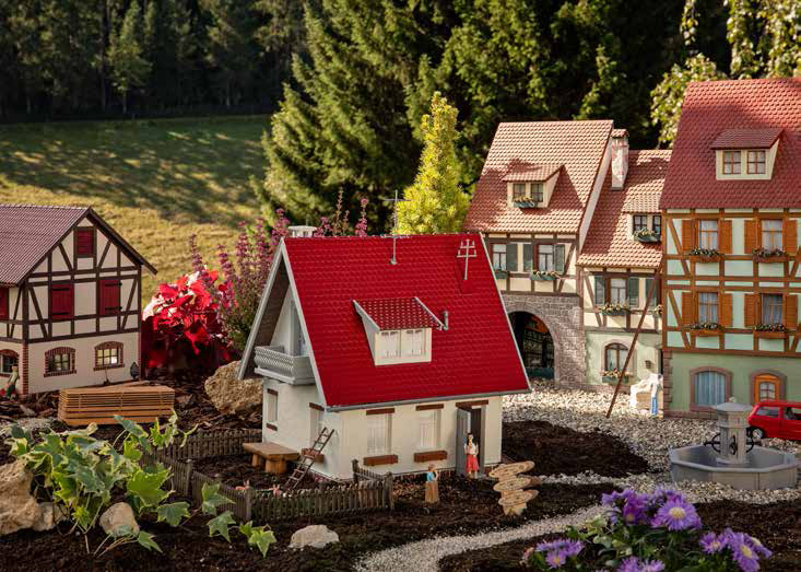 POLA 2024 - 331092 - Einfamilienhaus -  Lndliches Einfamilienhaus mit hell verputzter Fassade, hell grauem Holzbalkon, einseitigem Fachwerk im Giebel, zwei Dachgauben und einer beweglichen Tr.