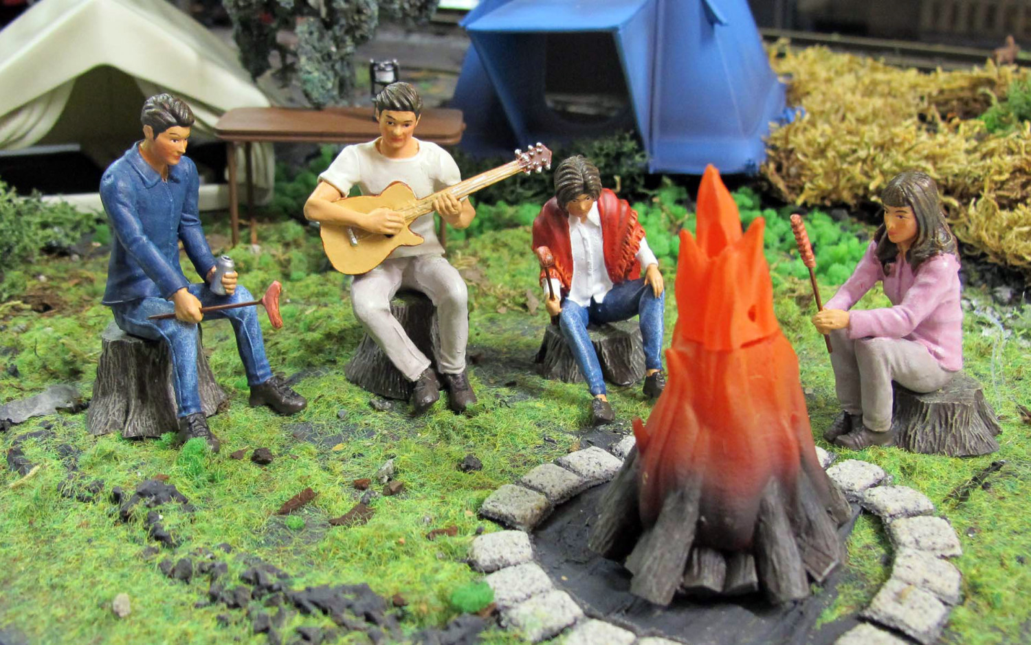 Hier sehen Sie die Neuheiten von Prehm-Miniaturen: Campingzelt, Steilwandzelt, Campingzubehr, Lagerfeuer, Camper mit Bratwurst, Camper mit Gitarre, Camperin mit Umhang und Bratwurst und die Camperin mit Bratwurst. Romantisch sitzen alle Metallfiguren um das Lagerfeuer, dass mit der Elektronik und LED sowie Raugenerator ausgestattet werden kann, auf einem Baumstumpf.  