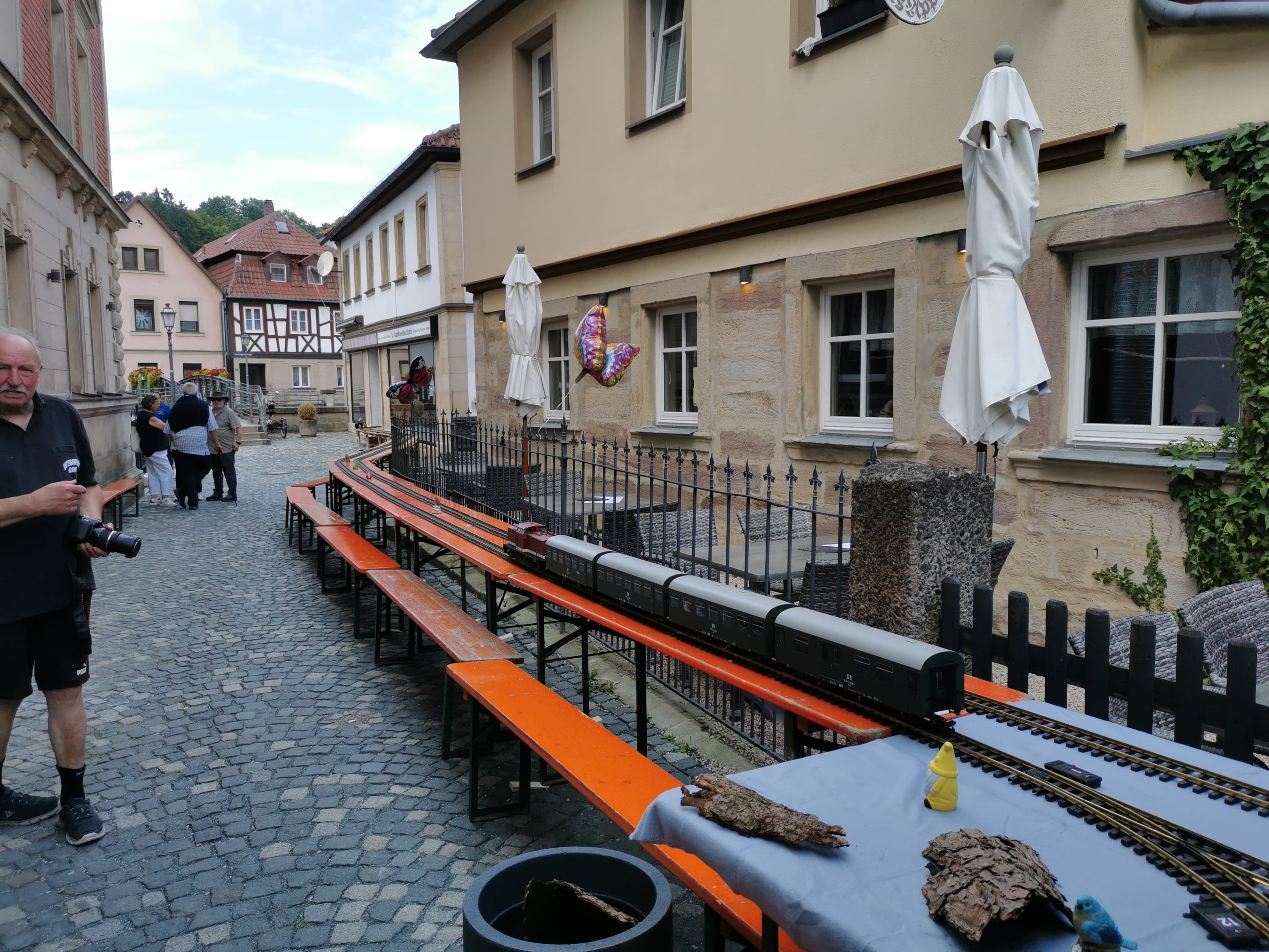 Auf Bierzeltgarnituren ging es dann zum Rundkurs der Gartenbahn beim Fest in der Rosenau. Hier wieder der Zug mit der V110 auf der Rückreise vom "Wendehammer".