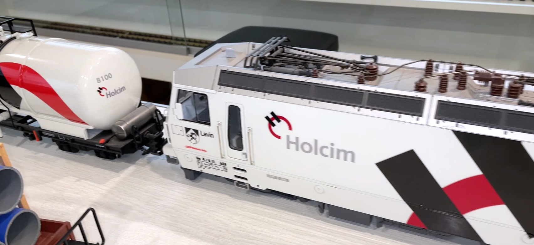 Bitte aufs Bild klicken und der Video startet. Fahrzeugbau Gohlke aus dem Harz prsentiert bei der Neuheitenvorstellung ihre selbst lackierten RhB Variaten. Holcim Zement Zug mit Ge 4/4 III, einem Kesselwagen und einem Containerwagen. Die grne Ge 4/4 III A&M AG - Entsorgung wurde mit einem Seitenkippwagen mit Beladung prsentier. Auch die BGA Ge 4/4 III hatten Gohlkes zur Ausstellung dabei. 