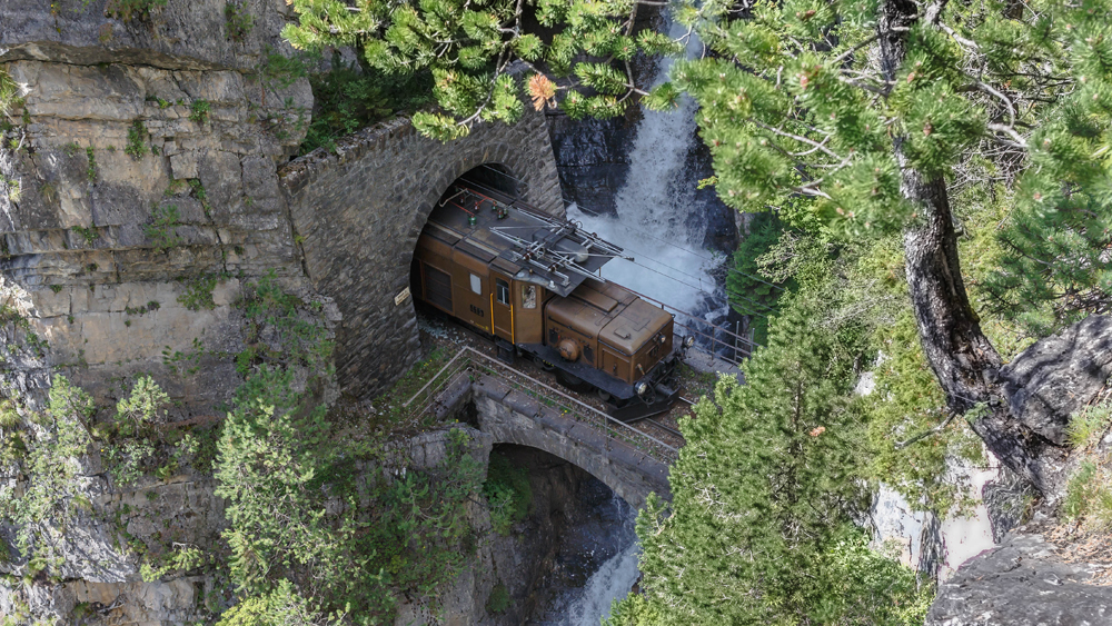 Foto: RhB.  Rhtische Bahn / Stefan Schulthess / Nostalgiezug am Brentritt - Krokodil als Lokomotive