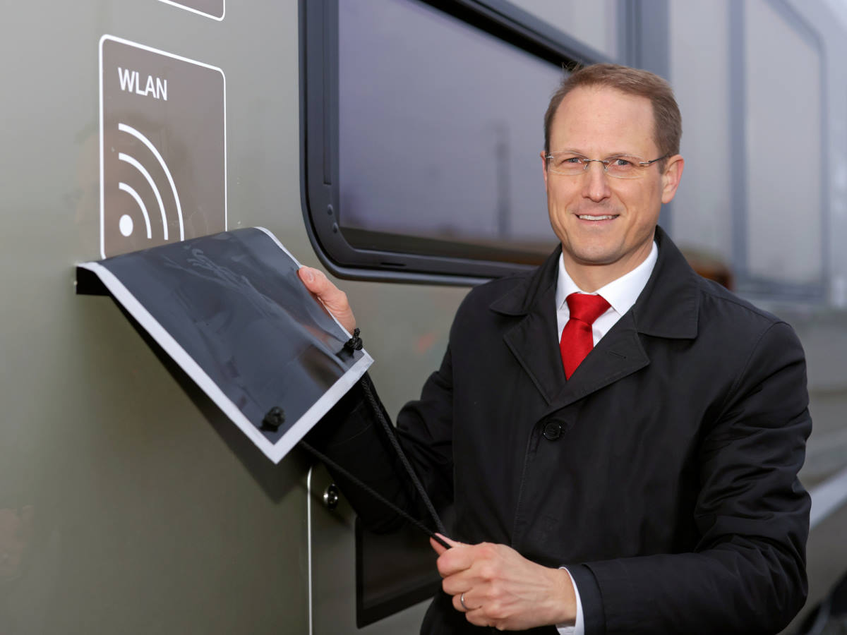 Foto: RhB -  Rhtische Bahn - Dr. Renato Fasciati enthllt den Mehrwert des Zuges: kostenfreies WLAN! 