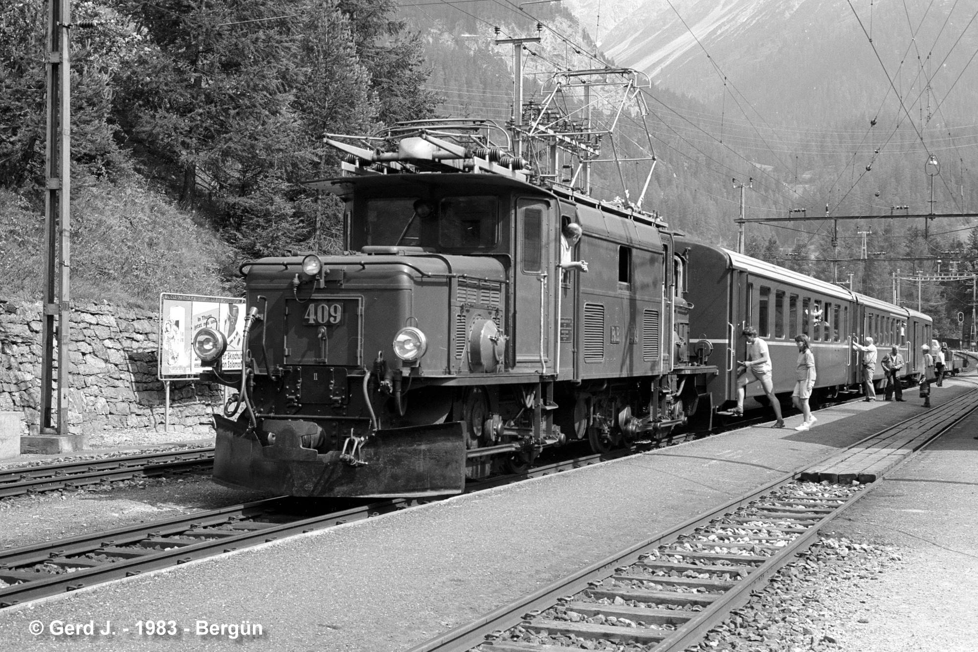 Ge 6/6 I der RhB Loknummer 409 mit Personenzug und Autoverladewagen im Bahnhof Bergn am 17. Juli 1983. 