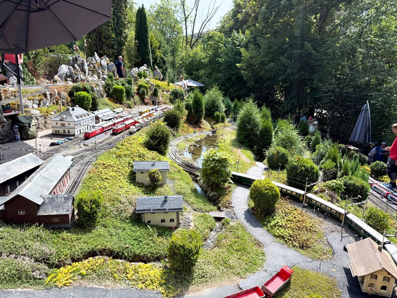 Seitlicher Blick auf die Anlage in Eschershausen. Hier der obere Bahnhof mit einigen Z�gen die zur Abfaht bereit stehen. Rechts im Bild ein Zug vom oberen Bahnhof duch die gro�e Schleife in eine Ebene darunter. Hier werden lange Z�ge gefahren. 