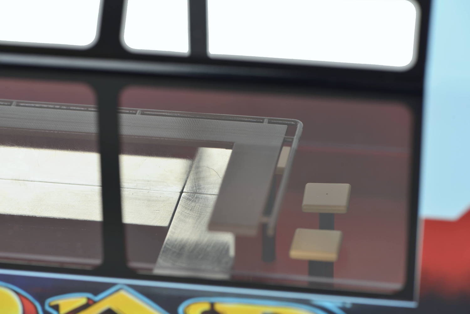Bei dem derzeitigen Verkaufspreis - unverbindliche Preisempfehlung: 419,99 EUR - könnte schon die Innenausstattung dem Original etwas näher gebracht werden. Ja, es stimmt, das einem Graffiti nachempfundenen Bild in UV-beständigem Digitaldruck ist aufwendig. Aber einmal eingespannt in den Druckautomaten läuft alles "vom Band". Das nachstehende Bild zeigt das Muster von der Produktpräsentation im Januar 2017 in Göppingen. Gut zu erkennen die Hocker mit hellem Holz. Die Glasablage am Tresen ist hier in dunklem Kunststoff ausgebildet. Schade, hätte nur die Kunststofffarbe getauscht werden müssen. kein Mehraufwand. Die im Originalbild dargestellten dunkeln Auflagen hätten auch aufgedruckt werden können.