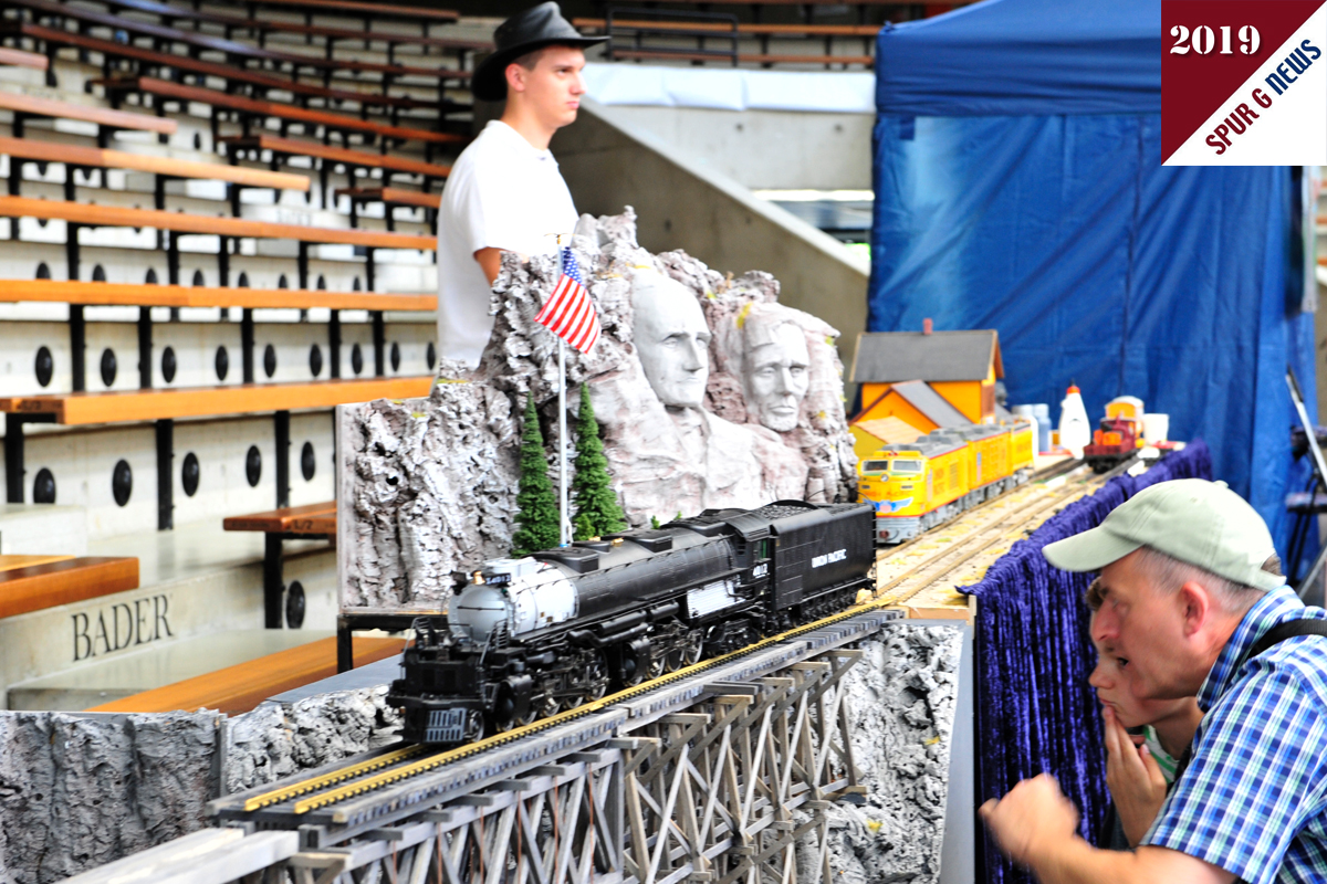 Das Bild zeigt "Vater und Sohn" vor der Brücke auf dem DIORAMA "Mount Rushmore" vom Club der LGB-Freunde Niederrhein in der EWS Arena. Hier wurde nicht nur der Unterschied Diesel- zu Dampflok erklärt sondern auch US-Bahngesellschaften aufgezählt. Die beiden Loks auf dem Diorama sind von der UNION PACIFIC. Es gibt ja auch noch Pennsylvania Railroad oder BNS Burlington Nothern. Mehr sind mir auf die Schnelle auch nicht eingefallen.