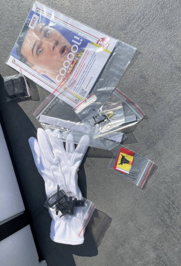 Die zuvor beschriebenen Zurüstteile der LGB Lok 26370 die Anleitung mit Zertifikat, die Baumwollhandschuhe aus dem Karton aufgelegt.