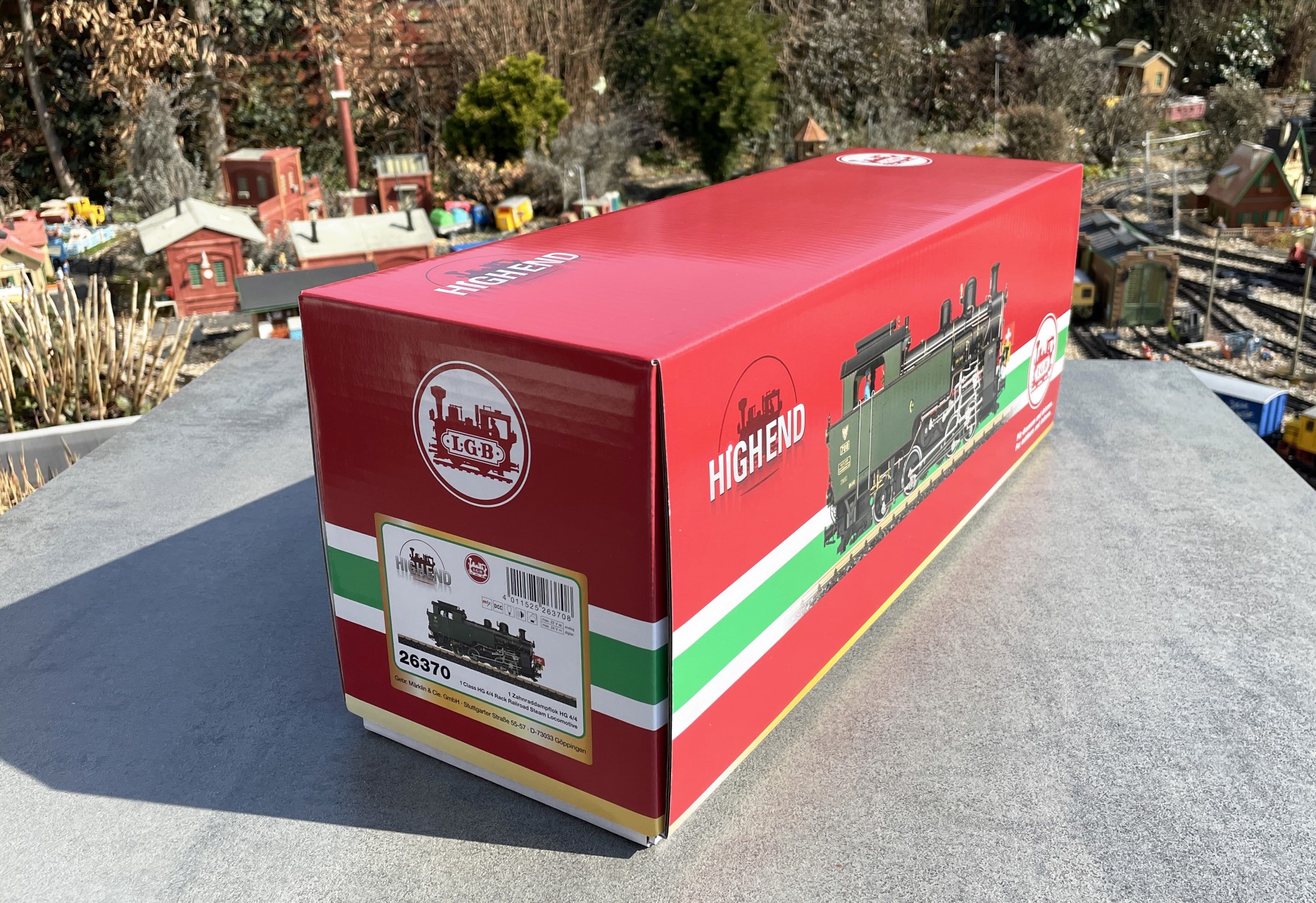 Der Verpackungskarton der HG 4/4 der DFB hat auf jeder Schmalseite einen Aufkleber. Hier die Seite mit Artikelnummer und Strichcode. Auf der anderen Seite ist nur die Lok zu sehen. Highend Metallmodell sticht auch schon auf der Seite des Kartons hervor. und die 6,3 KG sind nicht zu verachten. Bitte aufpassen, den Karton an der Unterseite anfassen zum Tragen. Seitlich angepackt kann der weiße Unterkarton herausgleiten.