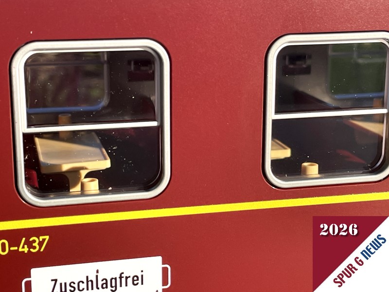 Der Blick durch die glasklaren Fenster mit den silbernen Rahmen zeigt die Inneneinrichtung mit Klapptisch und angedeudeter Lampe. Hier ist keine Beleuchtung eingebaut. 