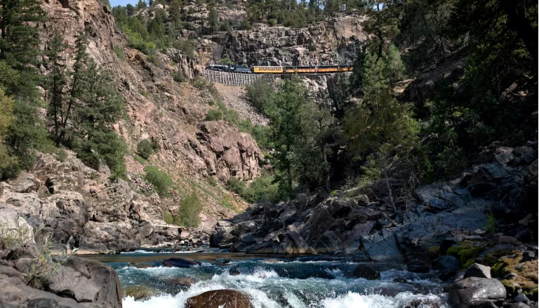 Willkommen bei der Durango & Silverton Narrow Gauge Railroad! Wenn Sie zum ersten Mal eine Reise mit uns unternehmen, laden wir Sie ein, sich zurckzulehnen, zu entspannen und die unvergleichliche Landschaft entlang des Weges zu genieen. Fr andere, die schon einmal mit uns gereist sind und mit unserem Zug und unserer westlichen Gastfreundschaft vertraut sind, mchten wir uns bei Ihnen bedanken, dass Sie zurckgekommen sind  wir freuen uns, Sie wieder zusehen! Steigen Sie ein und erleben Sie das "Goldene Zeitalter" auf unserer Eisenbahn, einem National Historic Landmark, das wirklich ein einzigartiges Erlebnis fr alle ist.