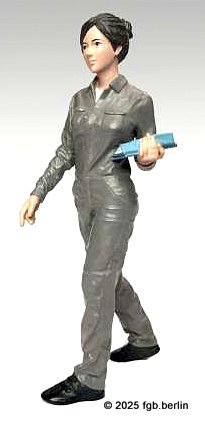 ADP-70102 - K�the tr�gt einen gr�nen Overall, schwarze Schuhe und hat eine blaue Schreibunterlage im Arm. 