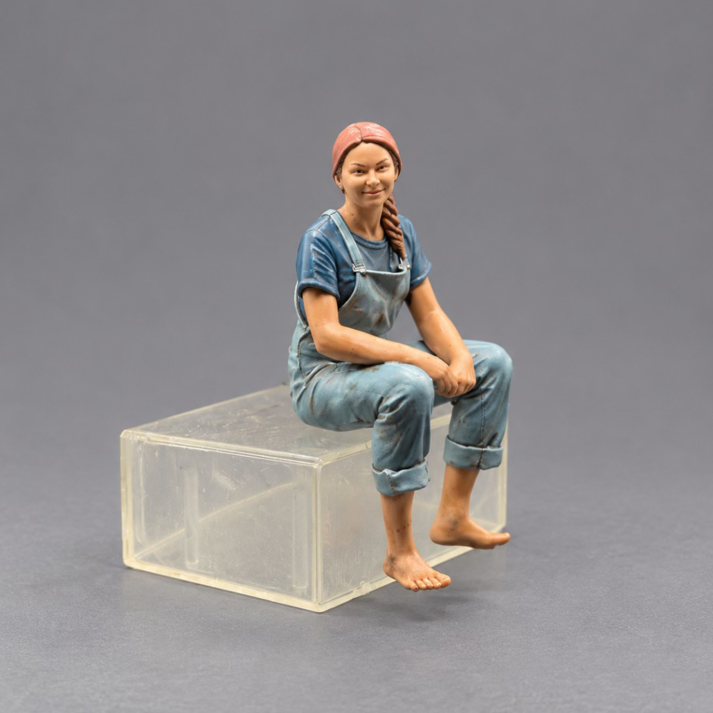 "Die hübsche" - sitzende Figur in blauer Latzhose. Passt auch an den Badesteg oder den Teich.