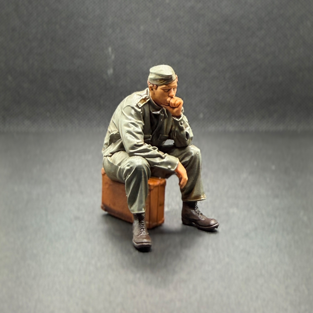 "Soldat" - mit Koffer. Sitzende Figur.