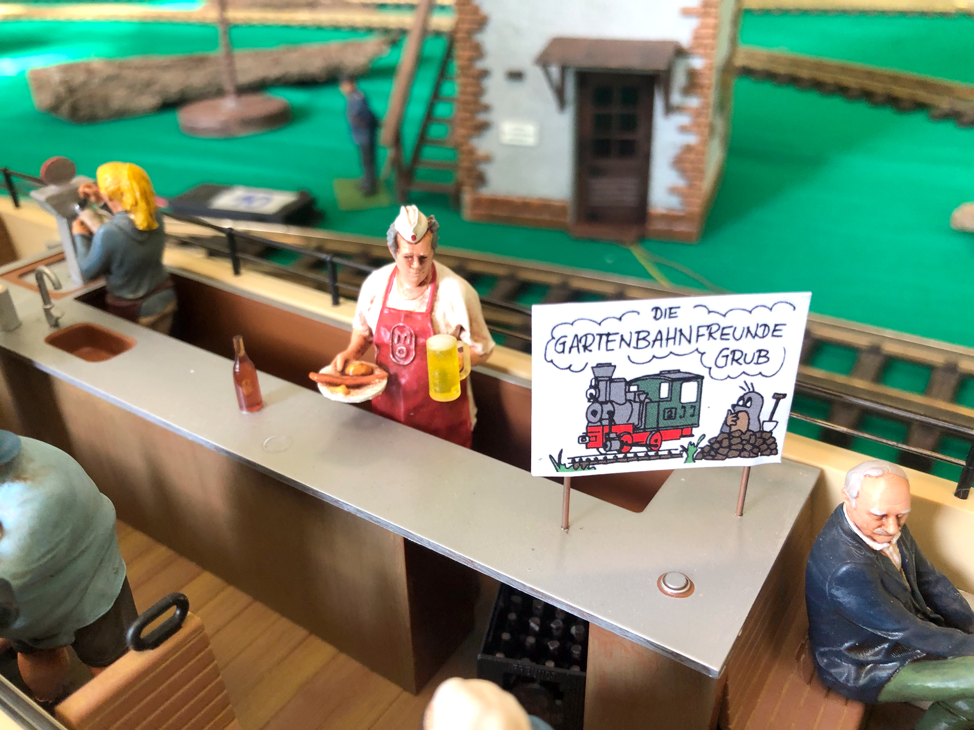 Auf dem Plakat gut zu erkennen: Der Wagen ist für die Gartenbahnfreunde Grub a. Forst reserviert. Serviert werden Bockwurst mit Brötchen und ein frisch gezapftes Bier! Na dann Prost!