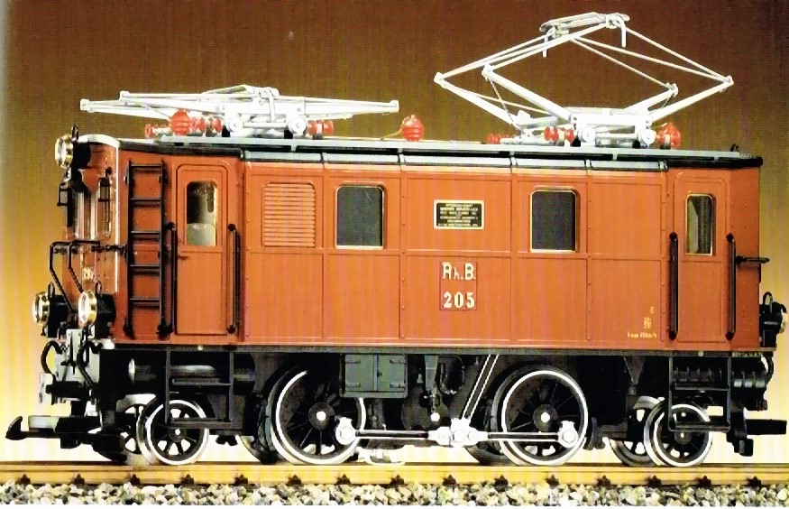 Ge 2/4 RhB - 4 achs. Elektro-Lokomotive. Hellbraunes Gehäuse, Leiter und Griffstangen schwarz. Dach und beide Dachstromabnehmer silberfarben, Isolatoren rot. Fabrikschild zwischen den Fenstern. 5-Volt Elektronik. Lichtwechsel (3 x Spitzenlicht - 1x Schlussleuchte. Lok Speichenräder schwarz.