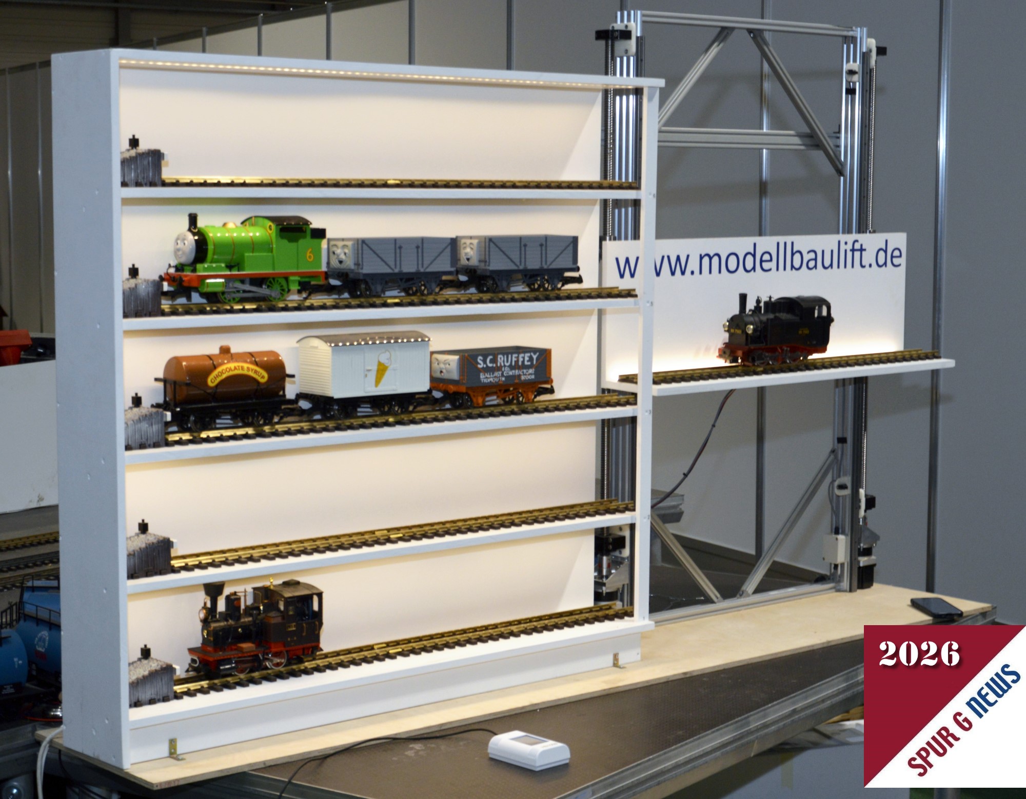 In Halle 3 wurde von der Firma www.modellbaulift.de ein Regal zur Aufbewahrung kleiner Züge bzw. Lokomotiven mit angebauten Lift gezeigt. Durch diese Konstruktion kann im Innenbereich ein Zugwechsel mit Lift erfolgen. Nach dem Spielen ist dann die Ausstellung in dem Vitrinenkasten zu sehen.