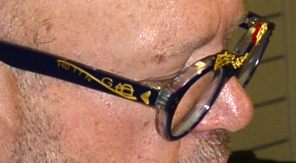 Auf dem rechten Brillenbgel sind die Produkte in als Piktogramme in Gold aufgesetzt: H0, TT, N, G, Huser und eine Linie deutet die Gleise an. 