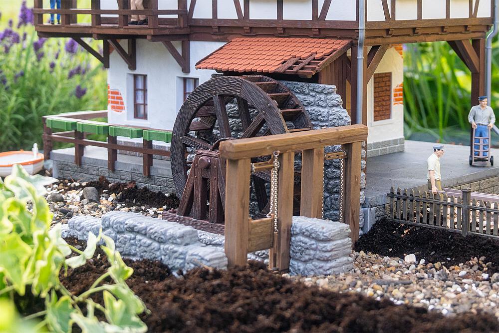 POLA Art. Nr. 333235 - Das Wasserrad mit gemauertem Kanal zeigt traditionelle M�hlentechnik in detailreicher Ausf�hrung. Die fein strukturierte Holzoptik und die naturgetreu gestalteten Steinmauern f�gen sich perfekt in l�ndliche Umgebungen ein � ideal f�r M�hlen, Werkst�tten oder historische Anlagen. Das Wasserrad kann mit dem Bastelmotor Art. 330090 (liegt nicht bei) angetrieben werden und wird so zum lebendigen Element Ihrer Modelllandschaft