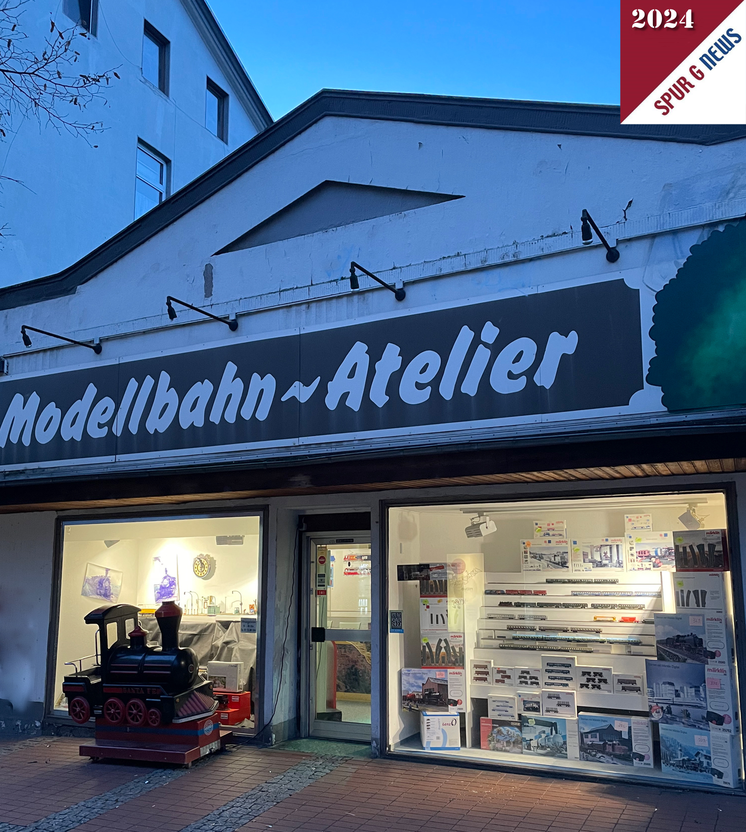 Das Bild zur blauen Stunde vom Eingang des Modellbahn-Atelier Renken in Essen. Es war hier kurz vor 18:00 Uhr am Tag der Neuheitenvorstellung 2024.