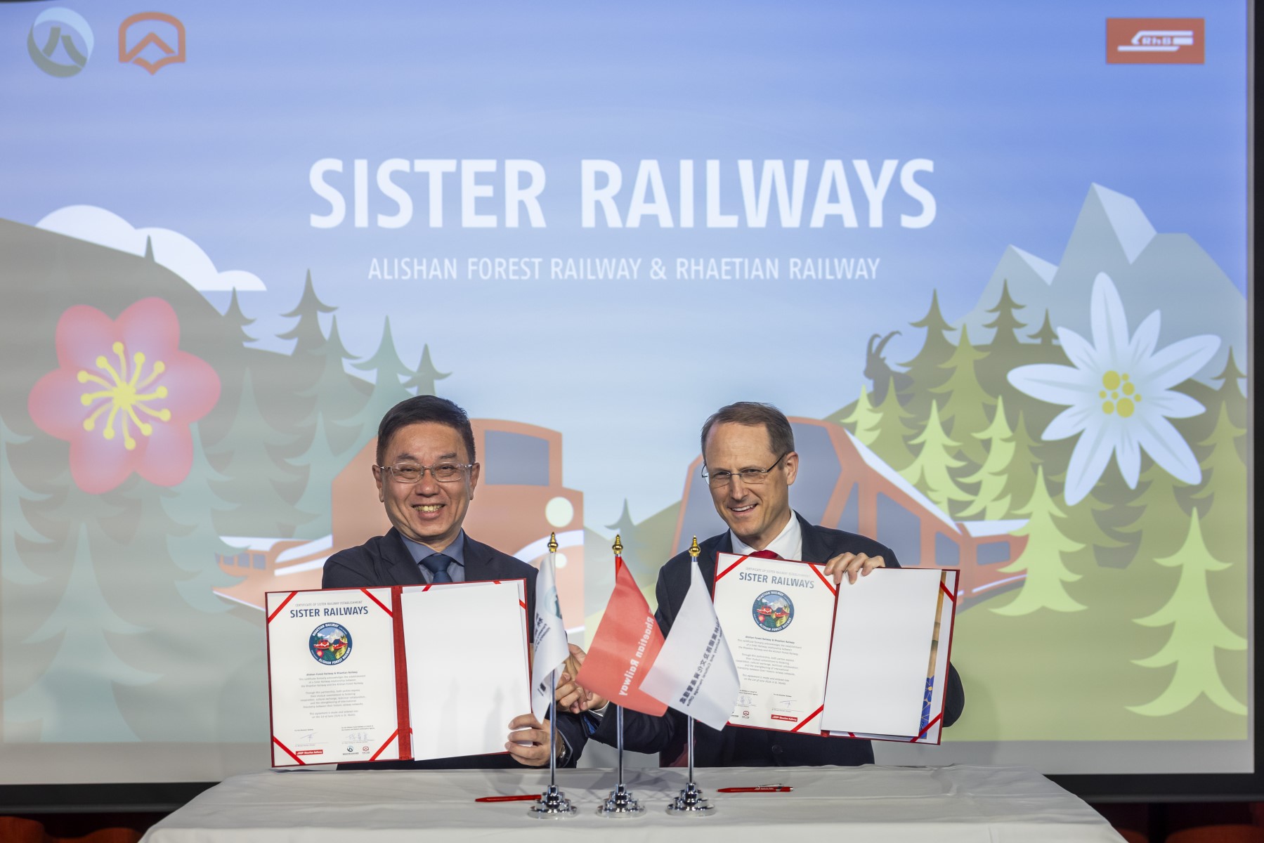 Die Urkundenunterzeichnung der RhB und der Alishan Forest Railway fand im Rahmen einer kleinen Feier im Theatersaal des Hotel Reine Victoria in St. Moritz statt. In seiner Begrüs-sungsrede betonte RhB-Direktor Dr. Renato Fasciati die Wichtigkeit solcher Partnerschaften: «Es freut uns sehr, mit Alishan Forest Railway eine weitere Partnerbahn aus Asien gewonnen zu haben und so die internationale Zusammenarbeit im Eisenbahnwesen weiter stärken zu können». Michel Pauchard, Leiter Marktmanagement RhB meinte ergänzend: «Asien ist für uns ein wichtiger Markt, in welchem wir derzeit mit einem Marktverantwortlichen und sechs Sales Repräsentanten aktiv sind. Neue Partnerschaften bedeuten neue Opportunitäten». Partnerbahnen der Rhätischen Bahn | Rhätische Bahn